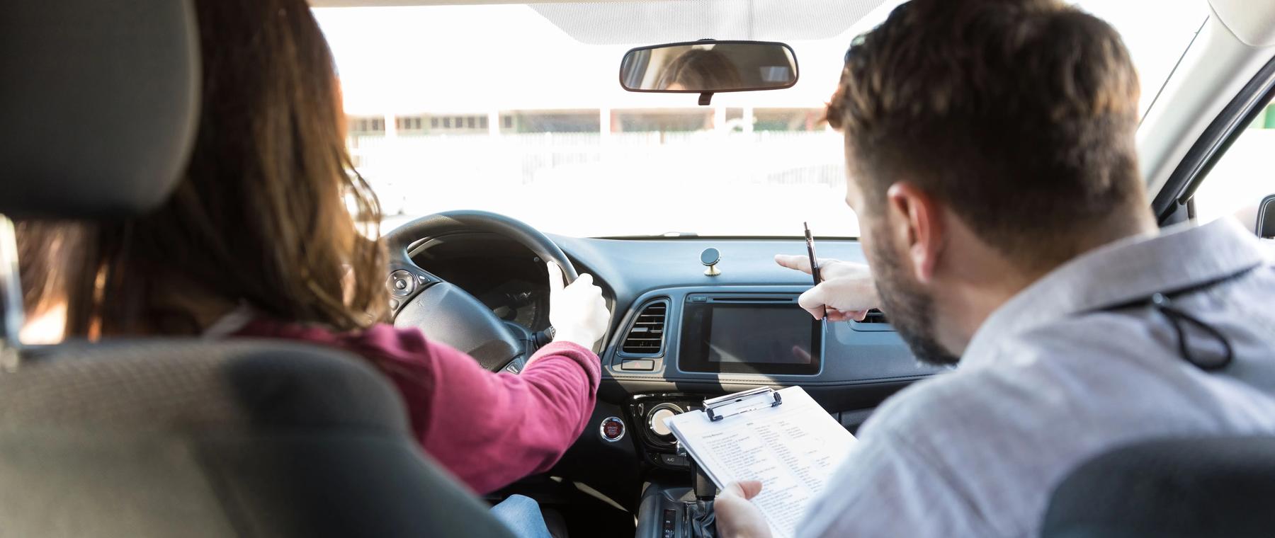 Fahrlehrer begleitet eine Fahrschülerin während der Fahrstunde